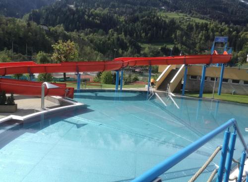 ein großer Pool mit rotem Dach in der Unterkunft Gästezimmer Lercher in Sankt Veit im Pongau