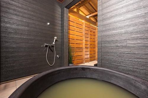 a bath tub in a bathroom with a shower at PEACE OF REST TAKASHIMA in Takashima