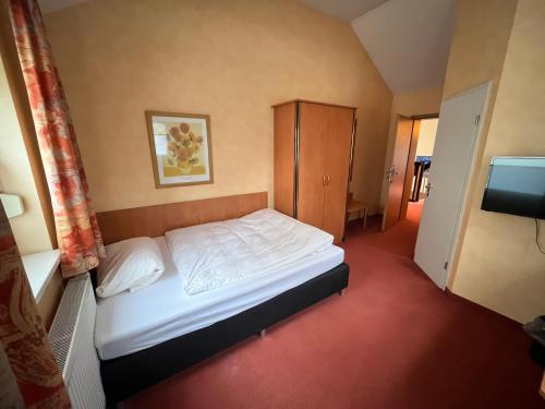 ein kleines Schlafzimmer mit einem Bett und einem TV in der Unterkunft Landhotel Ritter-Post in Angelbachtal