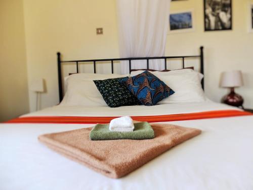 a white bed with a towel on top of it at Carpe Diem Guesthouse in Entebbe