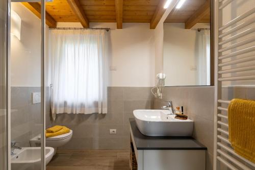 a white bathroom with a sink and a toilet at Mos Country House in Tremosine Sul Garda
