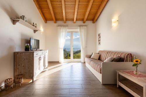 a living room with a couch and a television at Mos Country House in Tremosine Sul Garda