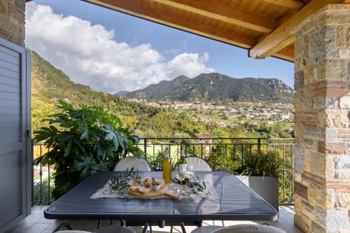 a table on the balcony of a house with a view at Mos Country House in Tremosine Sul Garda