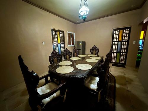 comedor con mesa negra y sillas en Shawn's Transient House at New Clark City en Calingcuan