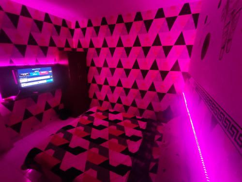 Teko的住宿－RDTROOM TRANSIT At Aeropolis，紫色客房 - 带一张粉红色灯床