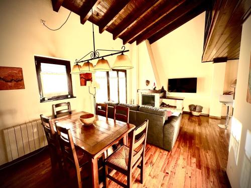 uma sala de estar com uma mesa e um sofá em Ático duplex a pie de pistas de esquí em La Molina