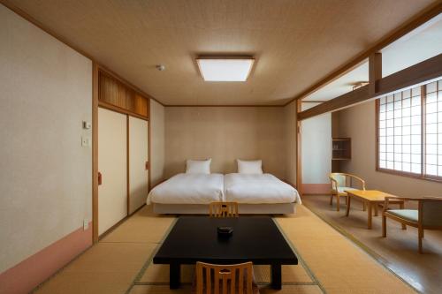 a bedroom with a bed and a table in it at 層雲閣 in Kamikawa