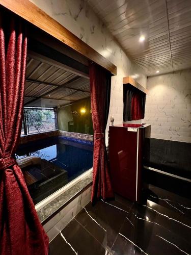 einen Pool mit rotem Vorhang in einem Zimmer in der Unterkunft MOUNT BUNGALOWS-1 BEDROOM Private pool chalet -wifi -private pool-ac in Lonavla