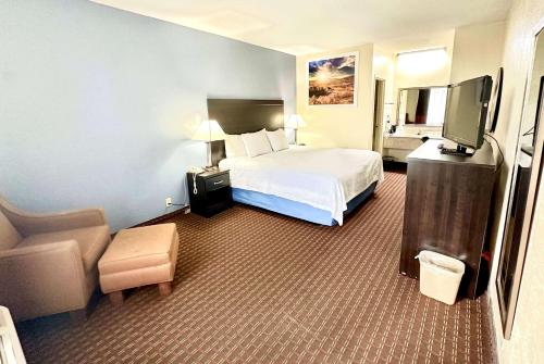 a hotel room with a bed and a television at Days Inn by Wyndham Easley West Of Greenville/Clemson Area in Easley
