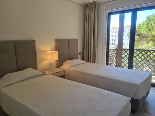 2 Betten in einem Hotelzimmer mit Balkon in der Unterkunft Apartamento Falésia by Garvetur in Albufeira