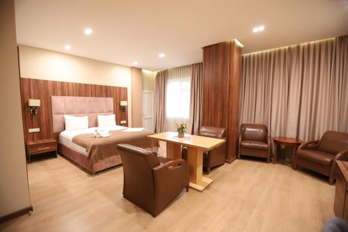 Park Suite Hotel في باكو: غرفة فندقية بسرير وطاولة وكراسي
