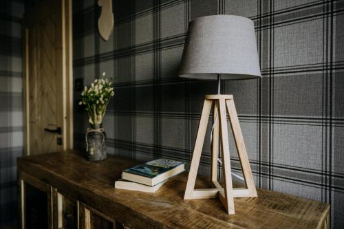 a lamp on top of a table with books at Luxury Chalet Kajmer in Jurgów