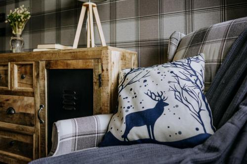 a pillow with a deer on it sitting on a chair at Luxury Chalet Kajmer in Jurgów