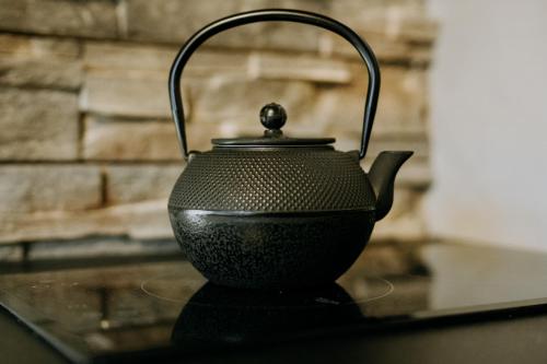 a black tea kettle sitting on a table at Luxury Chalet Kajmer in Jurgów