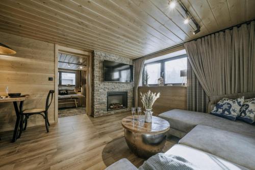 a living room with a couch and a table at Luxury Chalet Kajmer in Jurgów