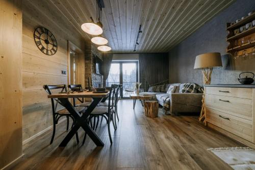 a living room with a table and chairs and a couch at Luxury Chalet Kajmer in Jurgów