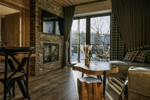 a living room with a couch and a table at Luxury Chalet Kajmer in Jurgów