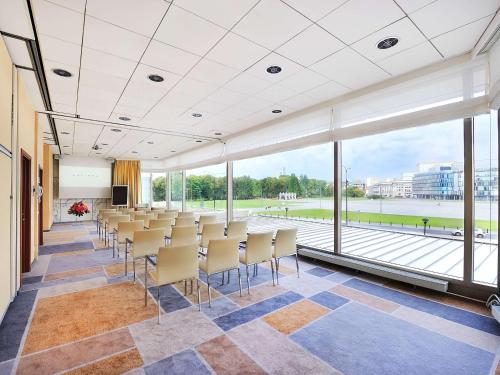 uma sala de conferências com cadeiras e janelas grandes em Sofitel Warsaw Victoria em Varósvia