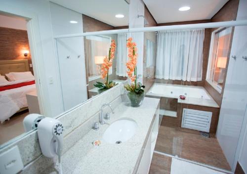 Hotel Terras da Finlândia في بينيدو: حمام مع حوض ومرآة كبيرة