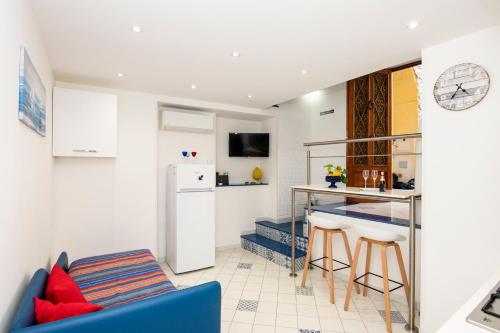 a living room with a blue couch and a kitchen at Da.Ma House a pochi passi dal mare in Meta