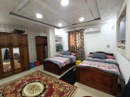 um quarto com duas camas e um tapete em شقه مفروشه كورنيش المعادى no Cairo