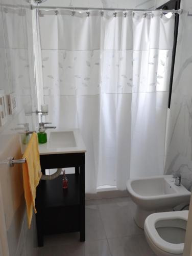 bagno con tenda da doccia bianca e servizi igienici di Depto centrico a La Plata