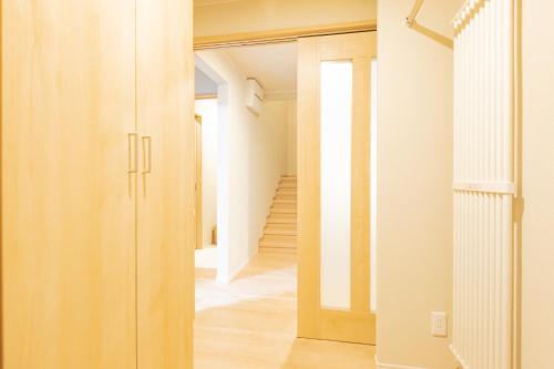 um corredor com uma porta que dá para um quarto em VILLA LOUISA em Furano