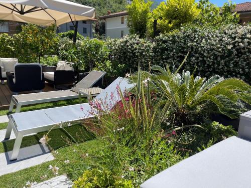 a garden with a table and chairs and plants at Hotel Villa Alberta in Nago-Torbole