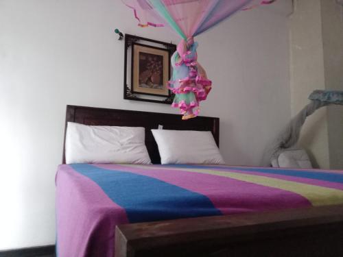 a bedroom with a bed with a colorful blanket at Lyon Villa in Talpe