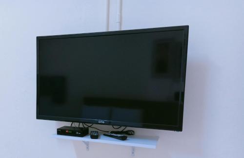 a flat screen tv sitting on a white shelf at Tunas Cottage 2 in Kuah