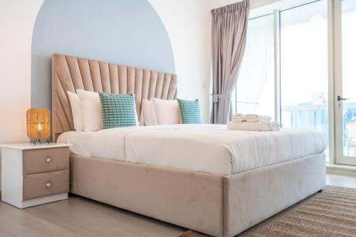 a bedroom with a large bed with a large window at Heaven Crest Vacation Homes Dubai Marina - 4 Bedroom Suite with Marina View near JBR Beach, Free Parking, Wi-Fi, Gym and Pool in Dubai