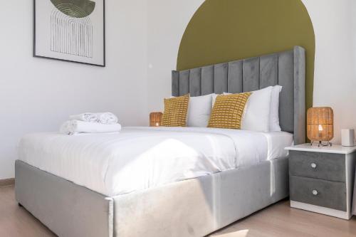 a bedroom with a large white bed with yellow pillows at Heaven Crest Vacation Homes Dubai Marina - 4 Bedroom Suite with Marina View near JBR Beach, Free Parking, Wi-Fi, Gym and Pool in Dubai