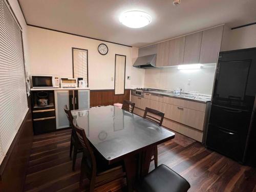 a kitchen with a table and chairs in a room at Hakuba Mountain Chalet in Hakuba