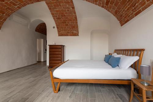 um quarto com uma cama e uma parede de tijolos em Domus Antiche Mura em Asti