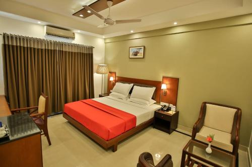 a hotel room with a bed and a desk and chair at Harbour Hotels in Pallipuram