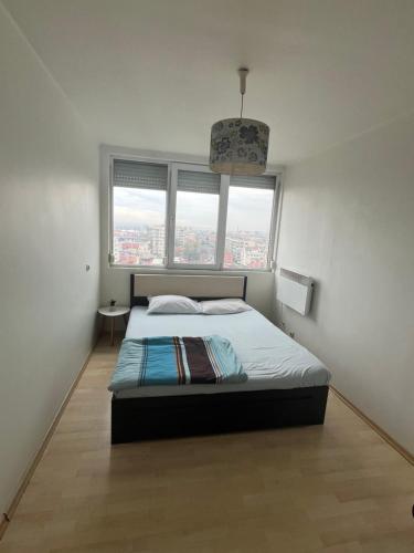 1 dormitorio con cama y ventana grande en Panoramic View Appt Russe en Ruse