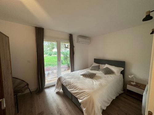 Un dormitorio con una cama y una ventana grande. en T4 neuf Porto Vecchio Calarossa, en Lecci