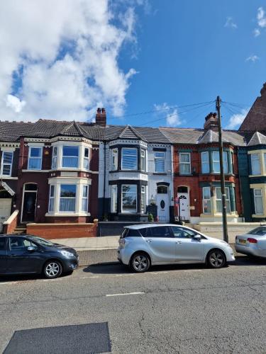 two cars parked in a parking lot in front of houses at ArklesFCLiverpool in Liverpool