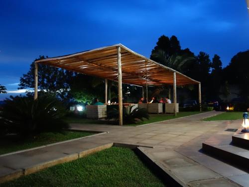 a pavilion with people sitting under it at night at Carpe Diem Guesthouse in Entebbe