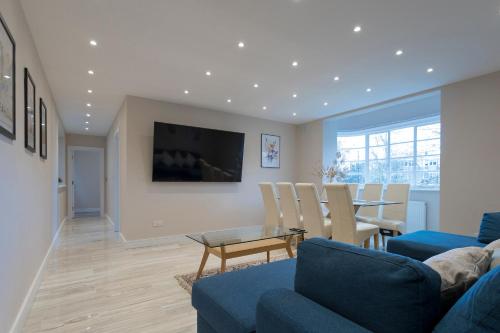 ein Wohnzimmer mit einem blauen Sofa und einem Tisch in der Unterkunft Luxury Apartment in Willesden in London