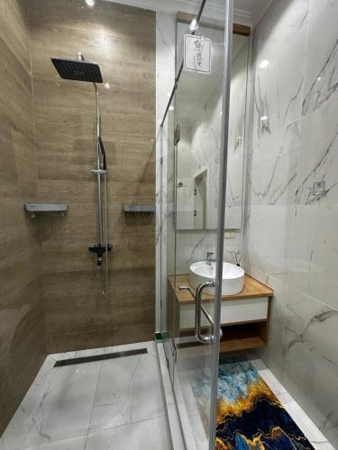 a bathroom with a shower and a sink at Villa Karakol in Karakol