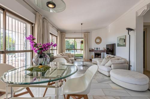 a living room with a glass table and white chairs at Nice Villa Anna Private Pool Garden Seaview in Benalmádena