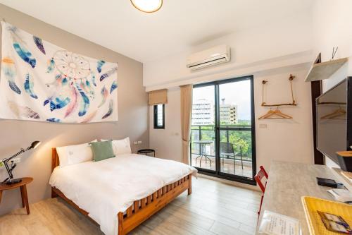 a bedroom with a bed and a large window at 水蛙春 in Hengchun South Gate