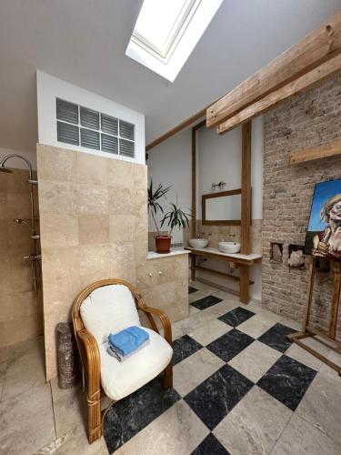 a bathroom with a sink and a chair in a room at Rustic room 2 next to beach in Constanţa