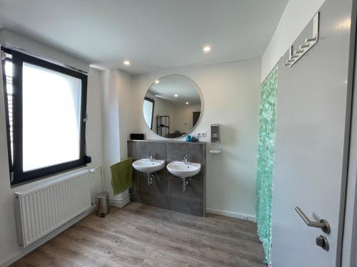a bathroom with two sinks and a mirror at MyTimeHouse in Ober-Ramstadt