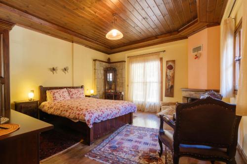 a bedroom with a bed and a wooden ceiling at Τα Πέτρινα της Ελάτης - Petrina Elatis in Elati Trikalon