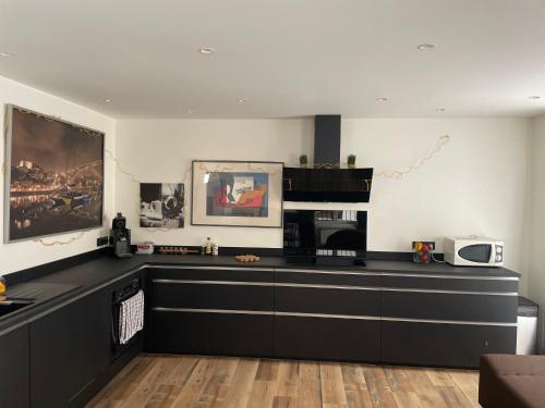a kitchen with black cabinets and a white wall at Appartement 77 in Lans-en-Vercors