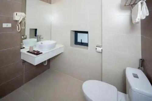 La salle de bains est pourvue de 2 lavabos et de toilettes. dans l'établissement Tigon Hotel - 148 Nguyễn Chánh HN by - BAY LUXURY, à Hanoï