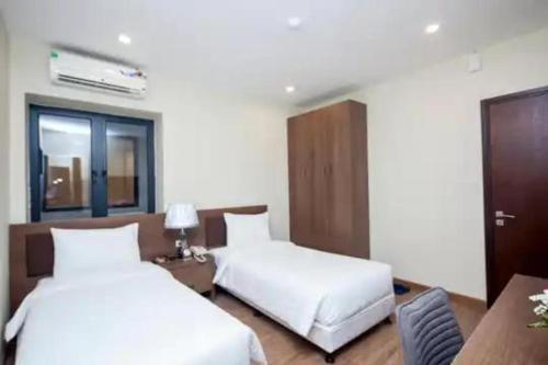 Cette chambre d'hôtel dispose de 2 lits et d'un bureau avec un siège social. dans l'établissement Tigon Hotel - 148 Nguyễn Chánh HN by - BAY LUXURY, à Hanoï