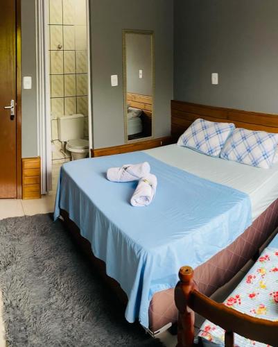 a bedroom with a bed with towels on it at Chalés do Parque Hospedagem in Penha